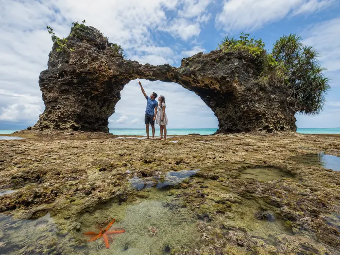 Couple at the Natural Bridge on Neil Island at low tide with a starfish in the tidal pool