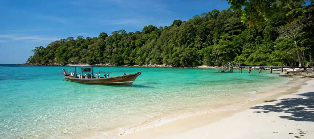 Things to do in Havelock Island: a dive boat on turquoise water by a forested white-sand beach