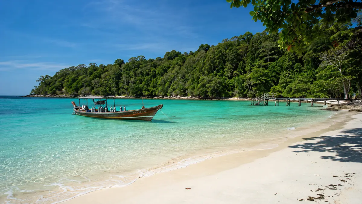 Things to do in Havelock Island: a dive boat on turquoise water by a forested white-sand beach