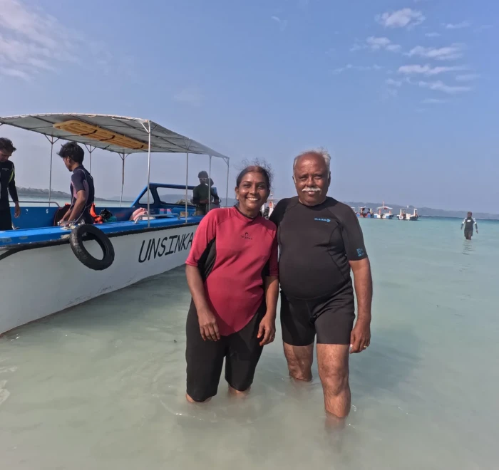 Couple on the beach beside the dive boat at Havelock