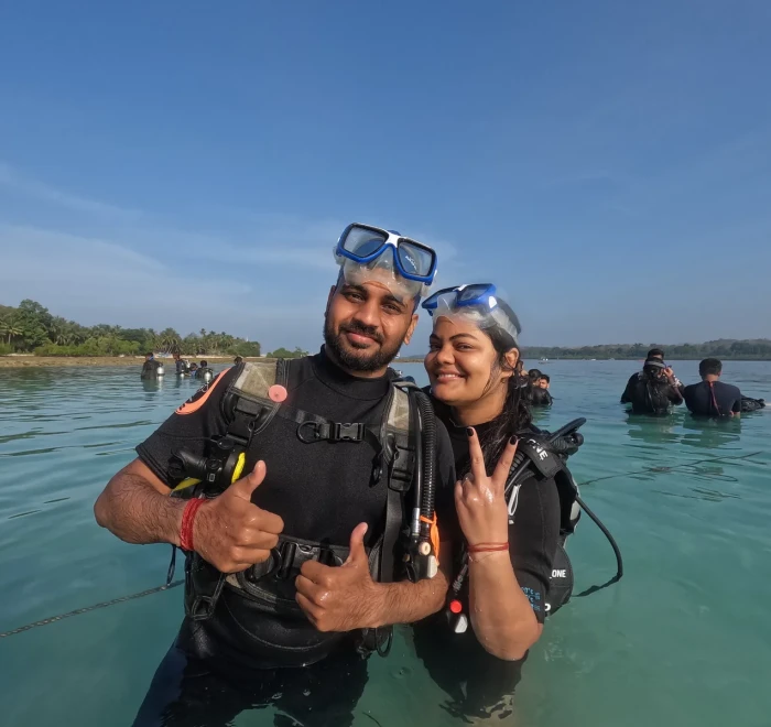 Couple giving thumbs up in the shallows with the mangroves behind