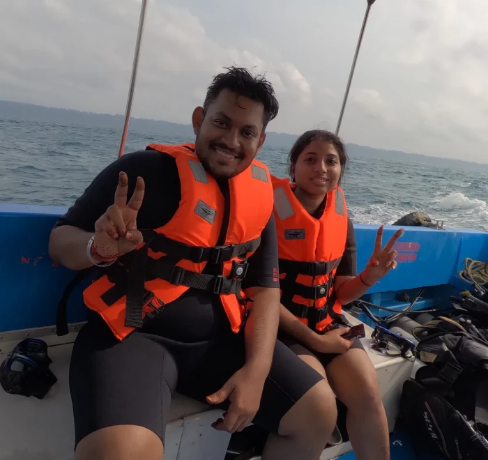 Couple in life jackets on the dive boat giving peace signs