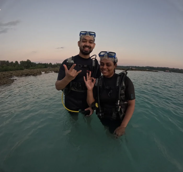Couple in the shallows at sunset after an evening dive