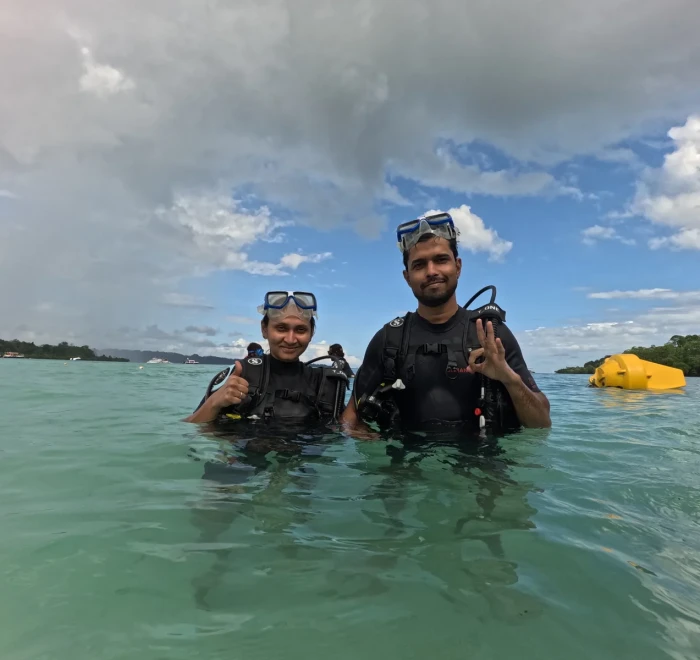 Couple standing in the shallows before a shore dive