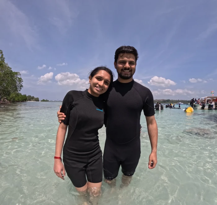 Couple standing together in waist deep water before their dive