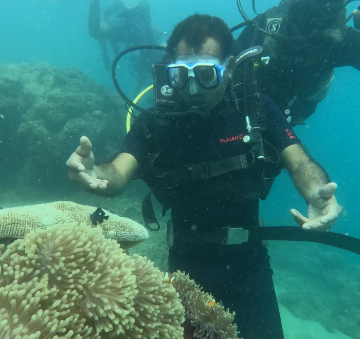 Diver beside an anemone with the guide close behind