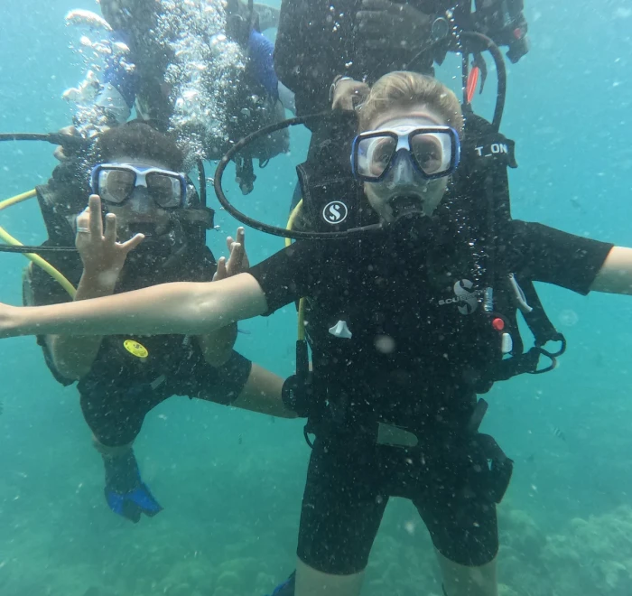 Diver with arms out and bubbles rising behind