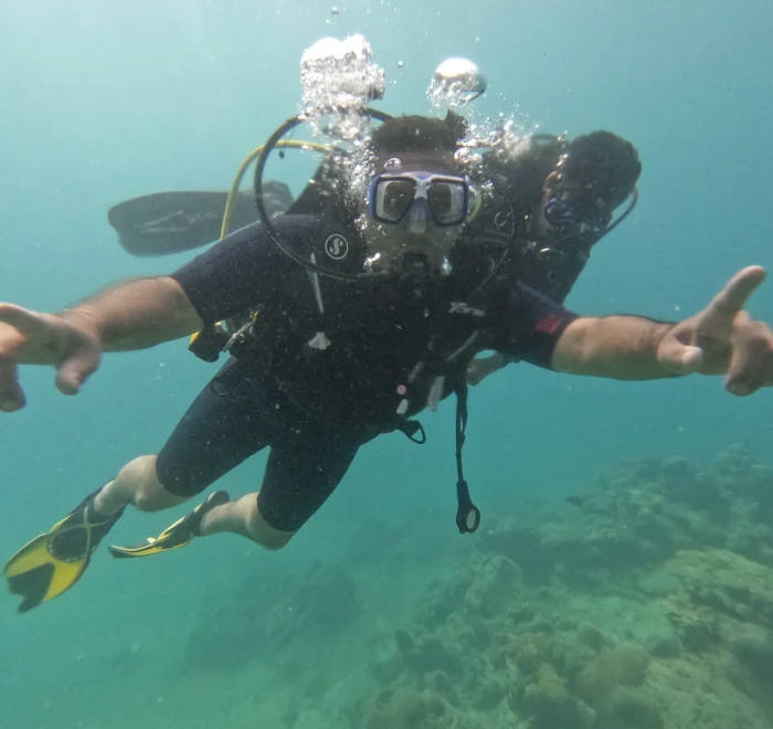 Diver with arms out gliding above the reef