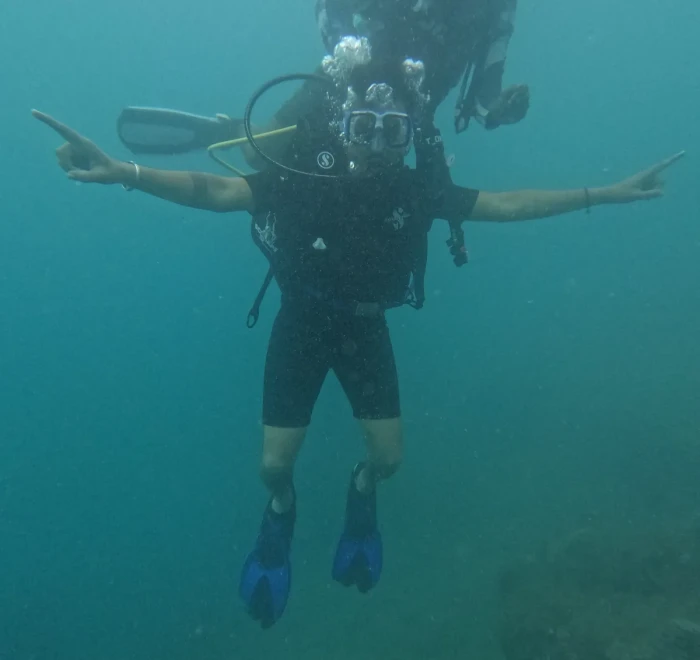 Diver with arms out mid-water on a fun dive