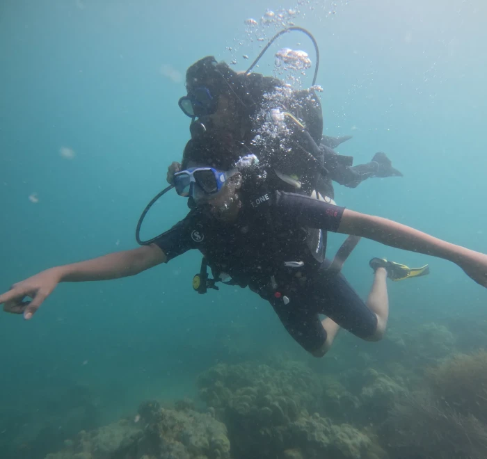 Diver with arms spread wide underwater on a fun dive