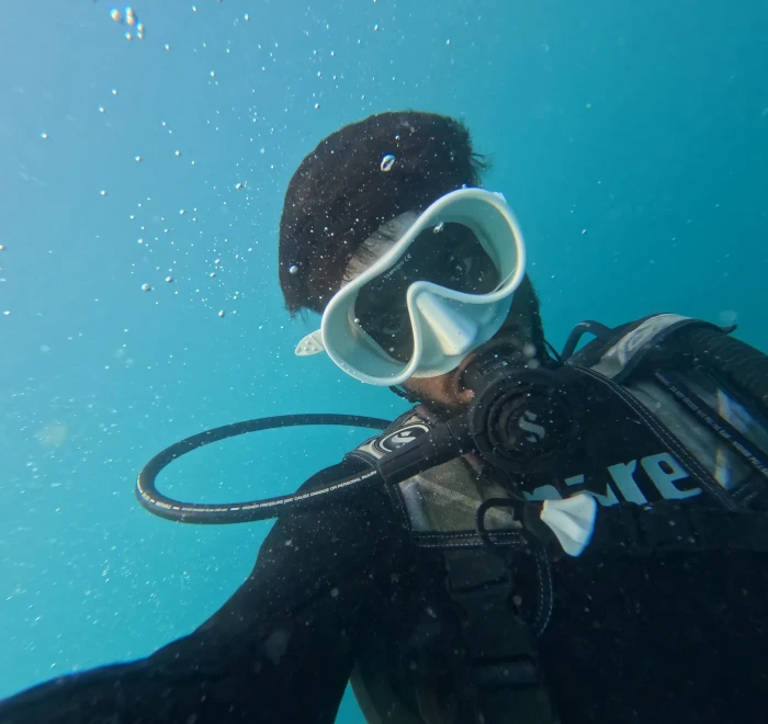 Diver close to the camera underwater in mask and regulator