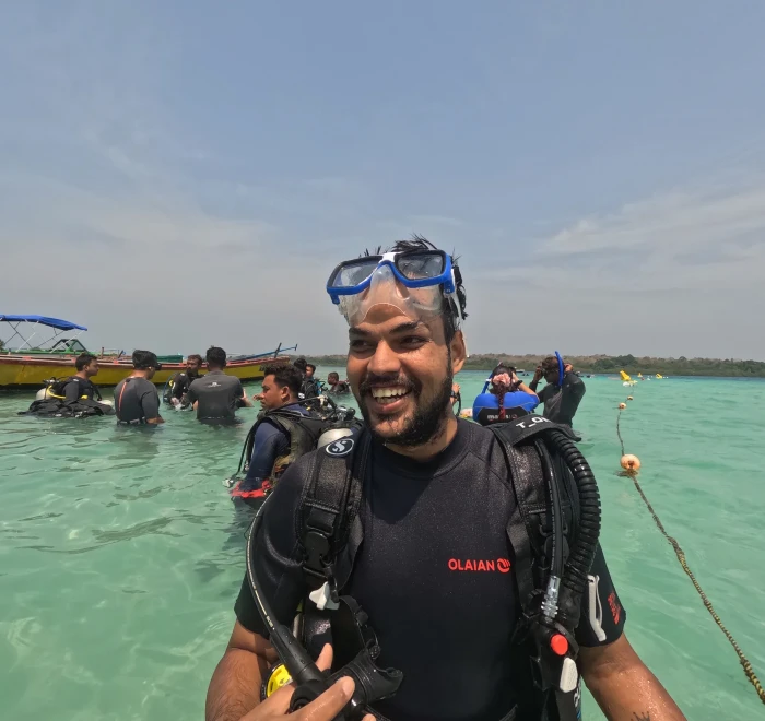Diver in full gear standing in the shallows before a shore dive in Havelock
