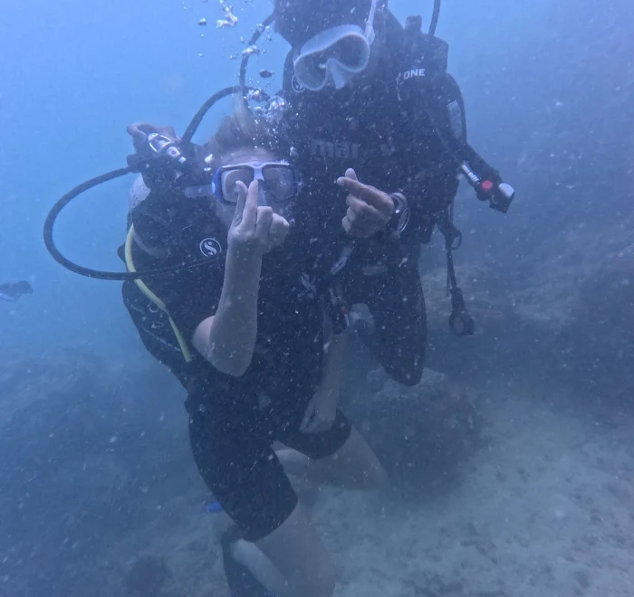 Diver giving the OK sign with the instructor behind