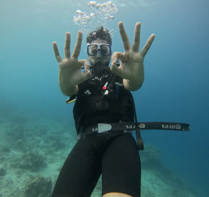 Diver giving OK signs with both hands while scuba diving in Havelock