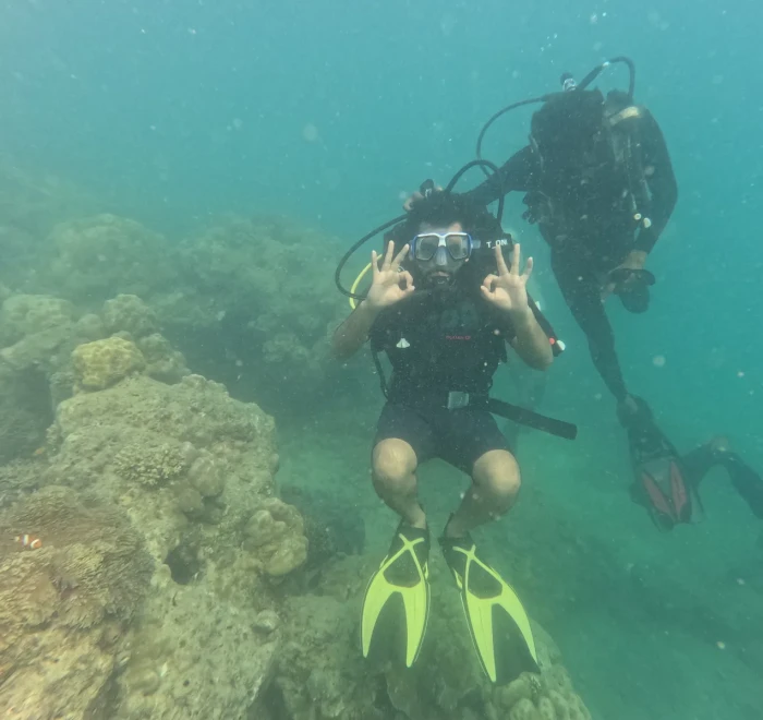Diver giving OK signs with the guide behind
