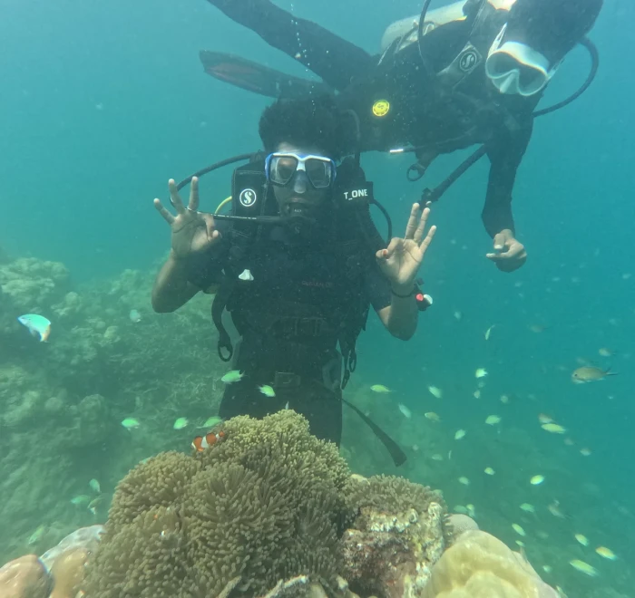 Diver giving OK signs above the reef