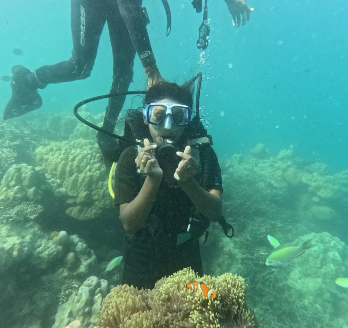 Diver giving peace signs above the reef