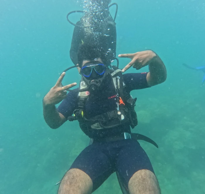 Diver giving peace signs underwater on a fun dive