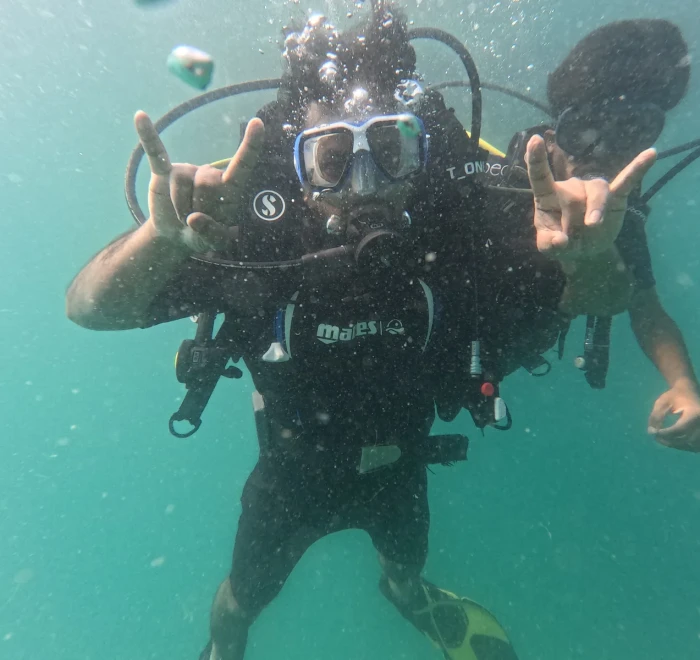 Diver giving shaka signs with both hands underwater