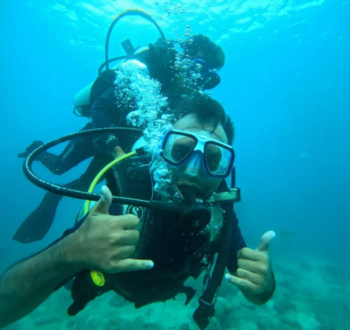 Diver giving a shaka and a thumbs up close to the camera