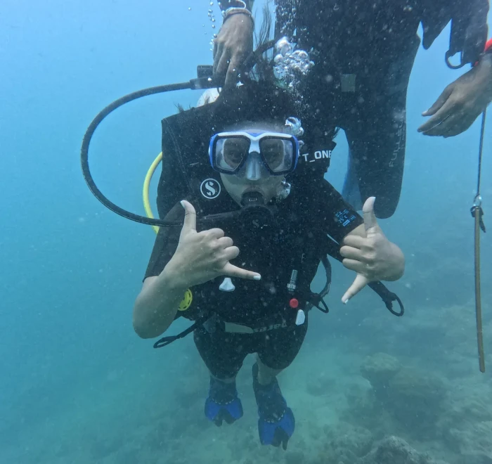 Diver giving thumbs up with both hands underwater