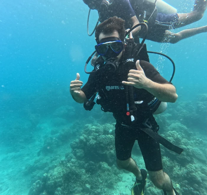 Diver giving a thumbs up with the guide behind