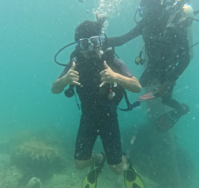 Diver giving a thumbs up with the instructor behind
