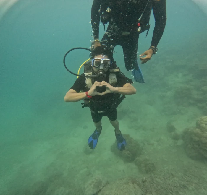 Diver making a heart shape with both hands underwater