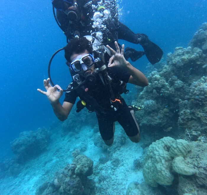 Diver signalling OK beside a coral head on a Havelock Island scuba diving trip