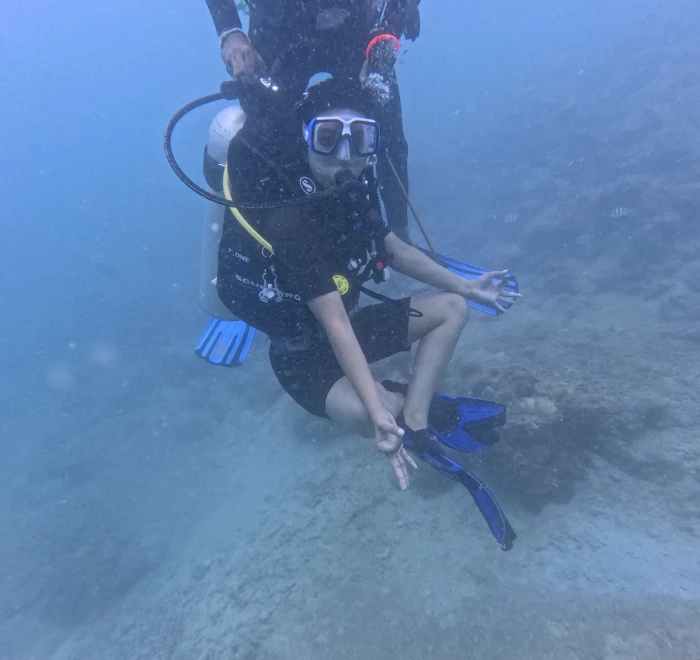 Diver sitting on the sandy bottom during a skills session