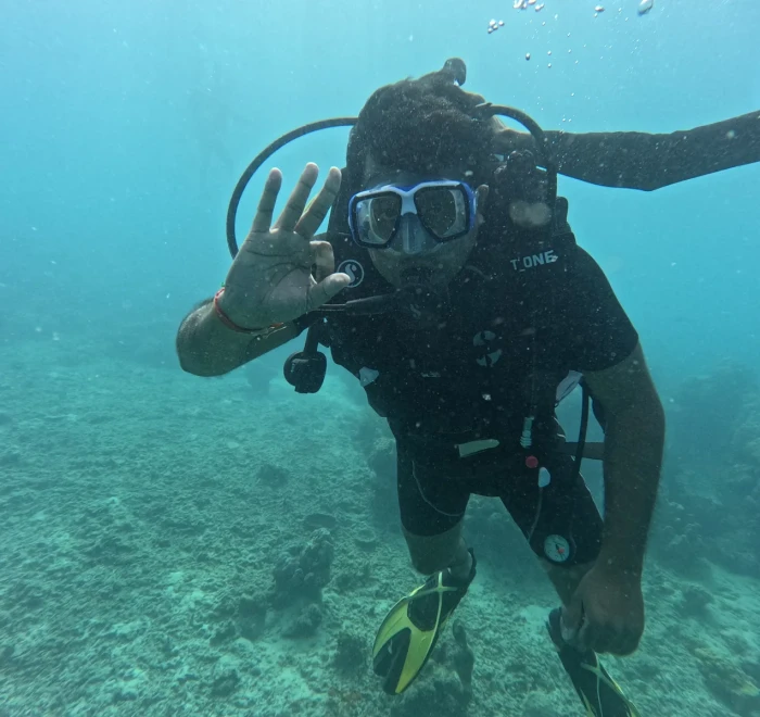 Diver waving to the camera above the reef