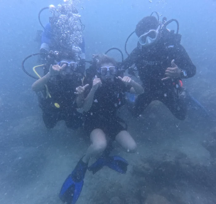 Group of divers together giving thumbs up
