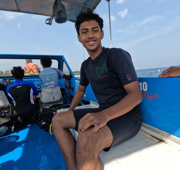 Guest on the dive boat with the gear stacked behind