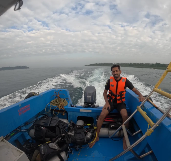 Guest on the dive boat with the tanks racked up, heading out to the dive site