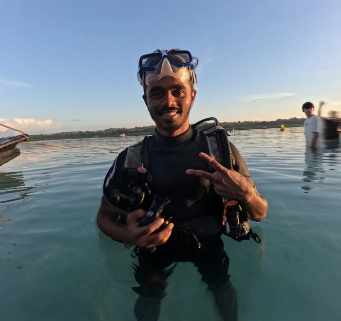 Guest giving the OK sign in the shallows at sunset