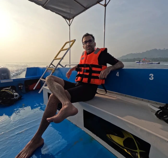 Guest in a life jacket on the dive boat at sunset