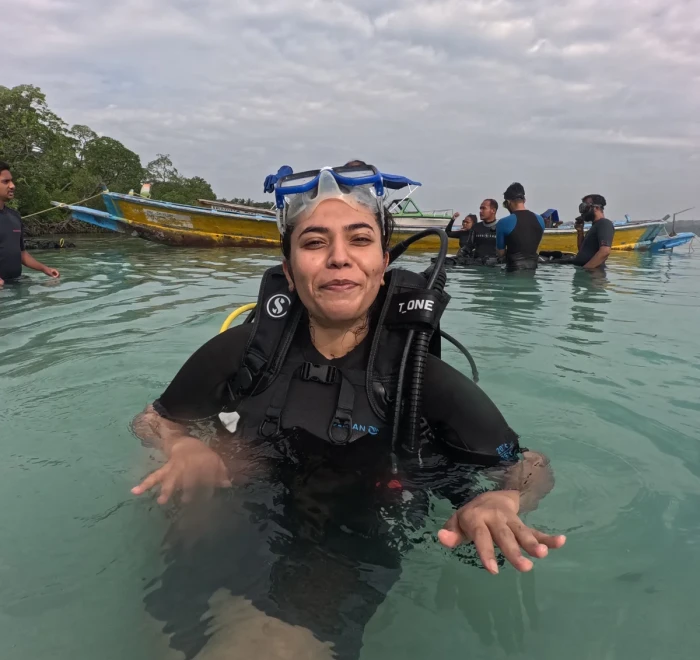 Guest in scuba gear in the shallows before a shore dive
