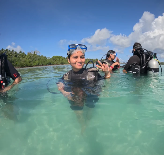 Guest in scuba gear standing in the shallows before a shore dive at Havelock Island