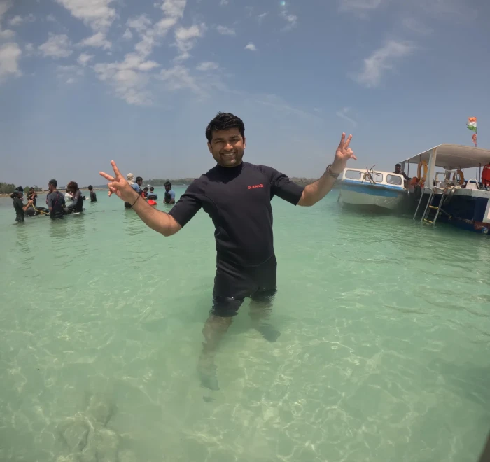 Guest in the shallows with the dive boats moored behind at Havelock