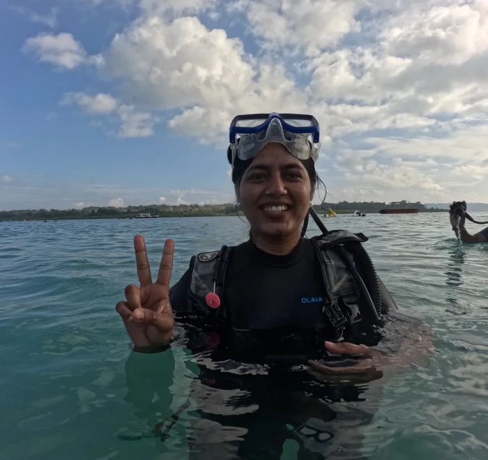 Guest standing in the shallows in her mask before a shore dive
