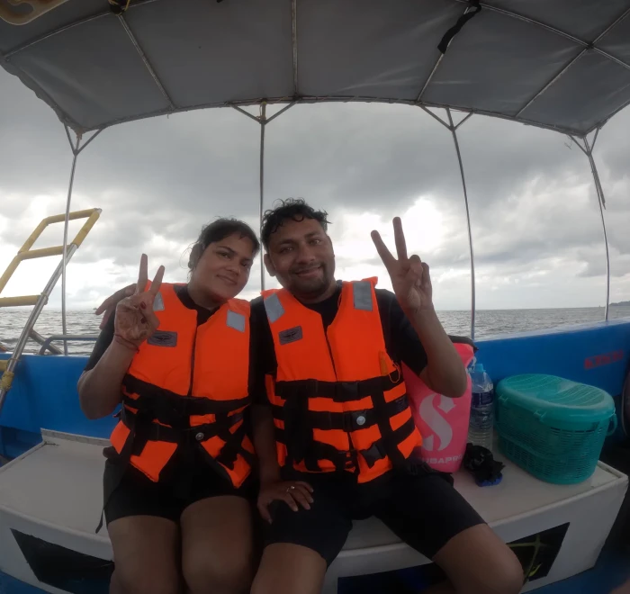 Guests in life jackets giving peace signs on the dive boat