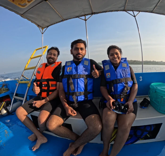 Three guests in life jackets sitting on the dive boat at Havelock
