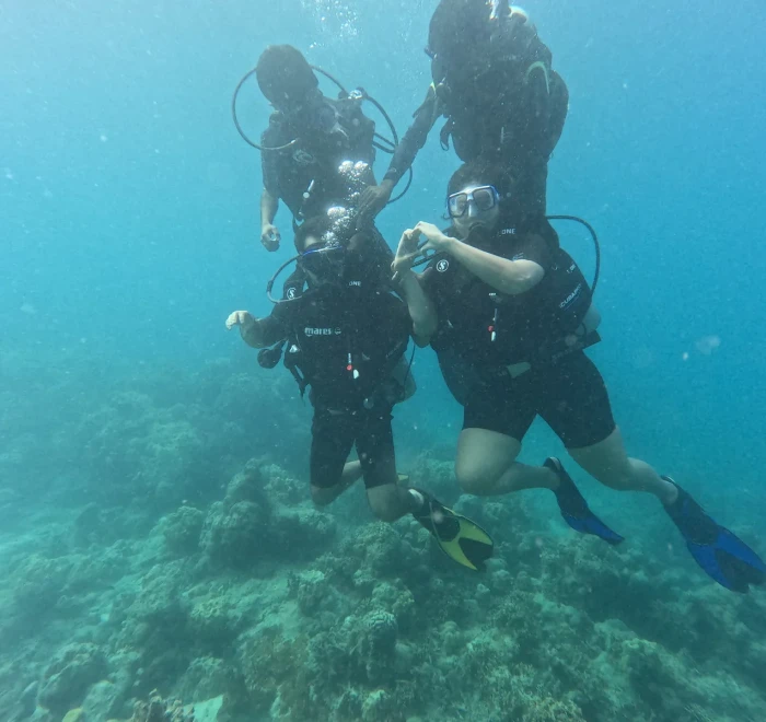 Two divers side by side over the reef