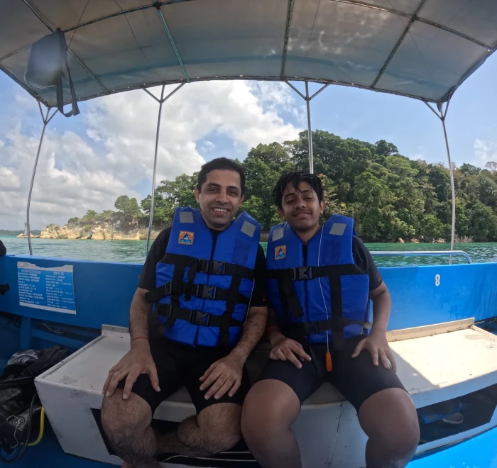 Two guests in life jackets on the dive boat near the shore