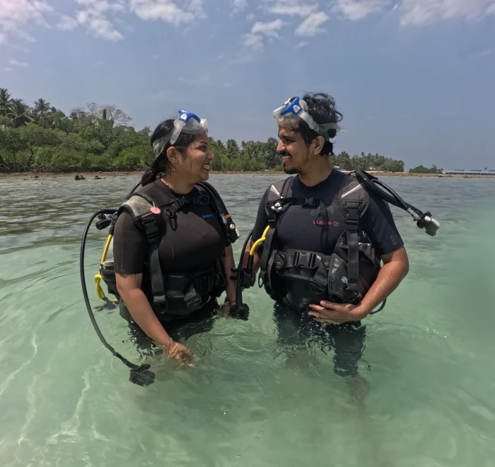 Two guests talking in the shallows before going in for a shore dive