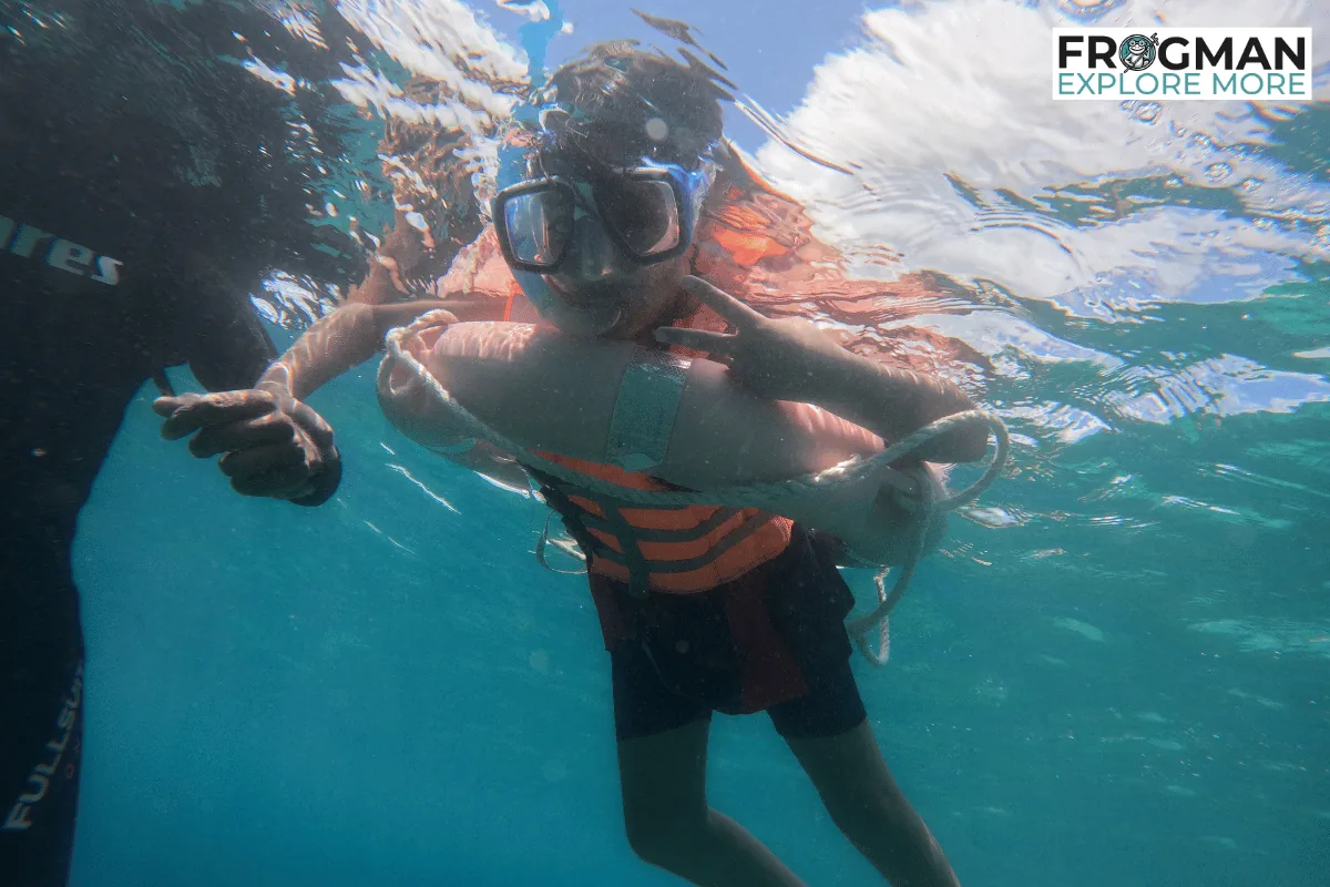Child in a life jacket snorkelling beside an instructor in Havelock, Andaman, the option for kids under 10
