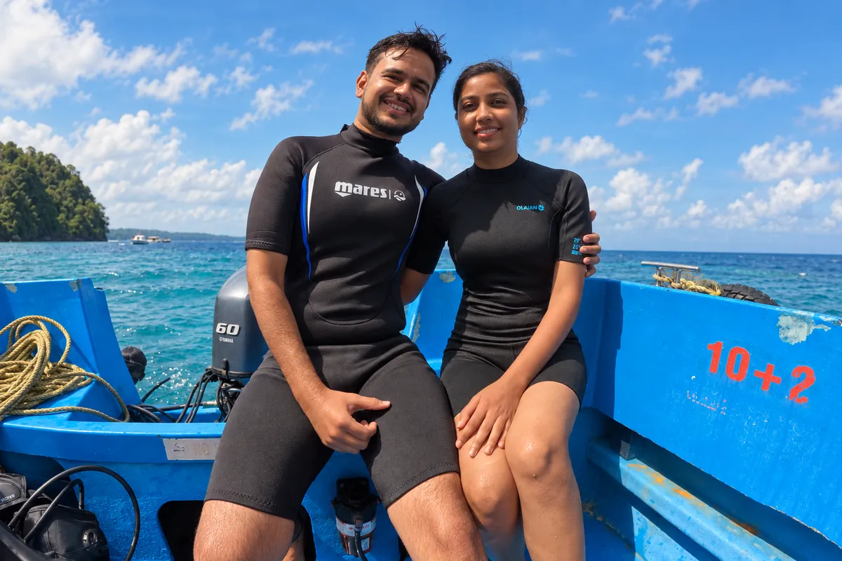 Couple in wetsuits sitting on the dive boat before a boat dive in Havelock, Andaman