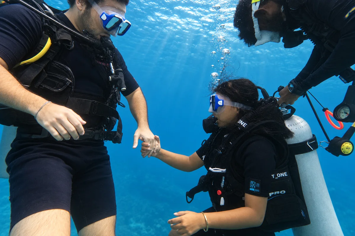 Instructor holding a beginner diver's hands on a try dive in Havelock, Andaman
