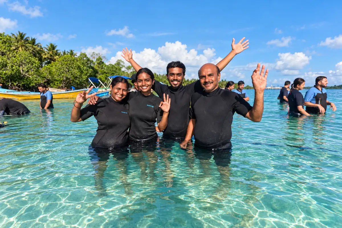 Group of five friends in wetsuits in shallow water after their scuba dive in Havelock, Andaman